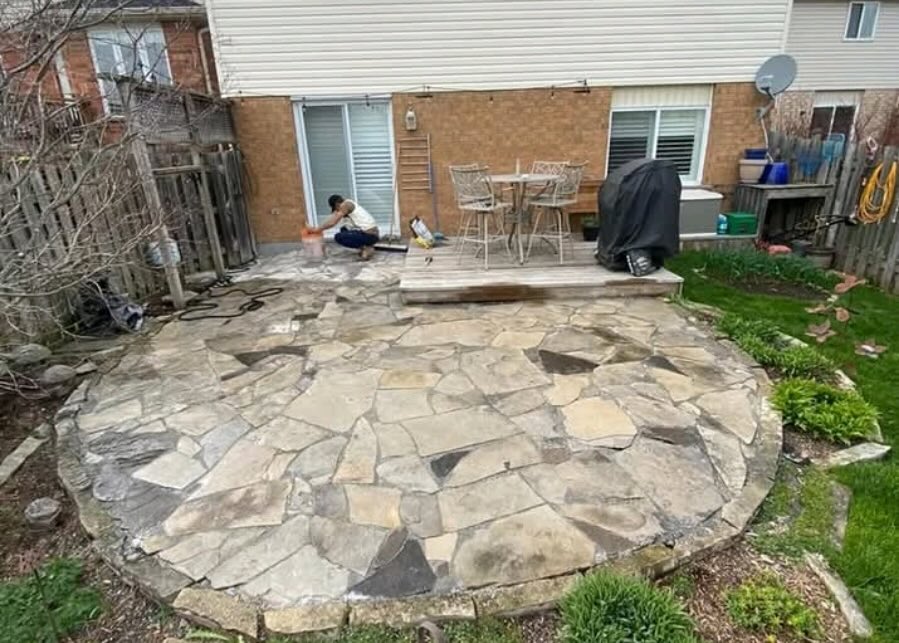 Natural flagstone patio installation in a residential backyard in Waterloo, Ontario — JD Landscape Design showcasing expert natural stone work and outdoor construction craftsmanship